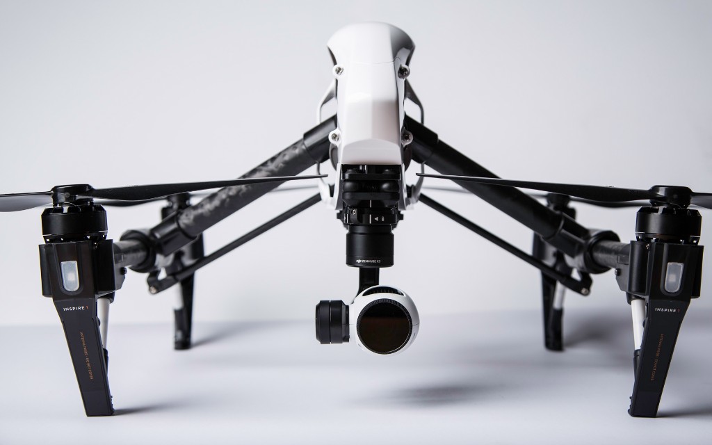 DJI Inspire 1 quadcopter with landing gear extended on a white studio background