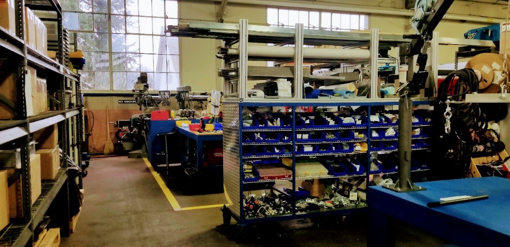 Oakland University incubator workshop with blue workbenches, component bins, and prototyping equipment.